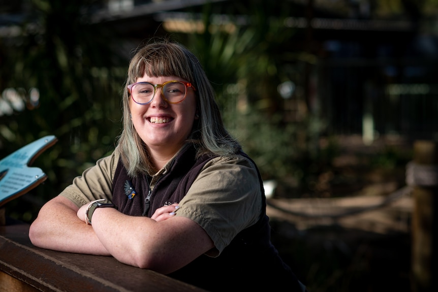 A woman with glasses and khaki uniform in the zoo