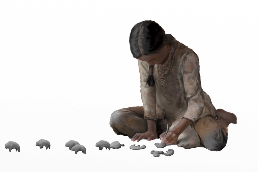 Reconstruction of Palaeolithic girl creating clay animal figures