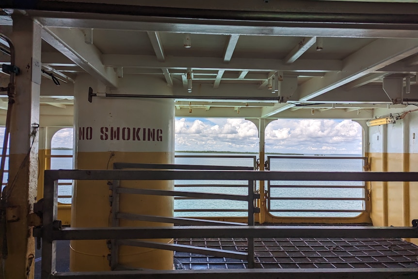 Looking out to see on board a vessel with cattle pens and a no smoking sign