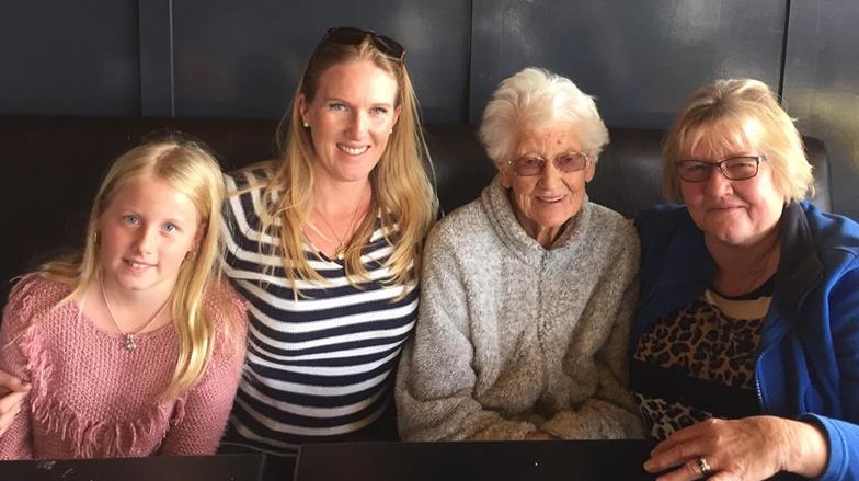 Four women from 92 to 9 sitting together in a cafe, smiling.
