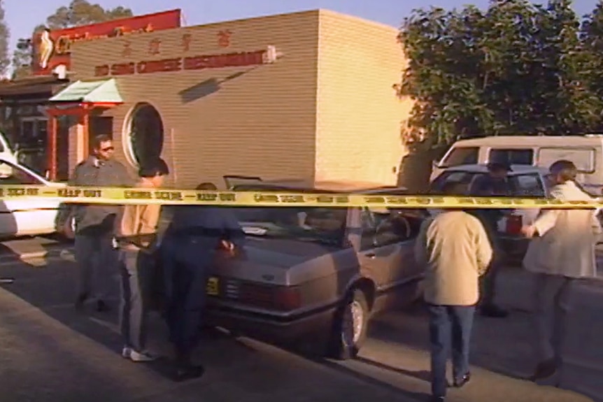 A crime scene with yellow police tape out front of a Chinese restaurant.