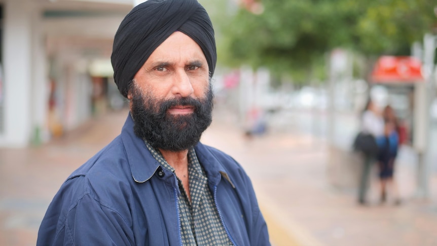 A man wearing a turban, standing on a street