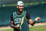 Nick Kyrgios holds a racket and gestures