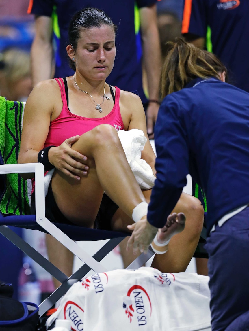 Latvia's Anastasija Sevastova has her right ankle taped by a trainer at the US Open