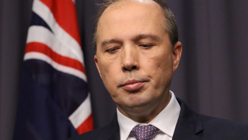 Headshot of Peter Dutton looking down when he pauses during a press conference.