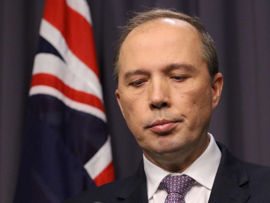 Headshot of Peter Dutton looking down when he pauses during a press conference.