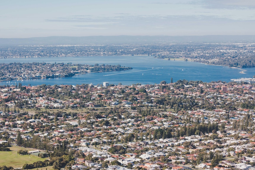 An aerial shot of a city – Perth – with a river running through it.