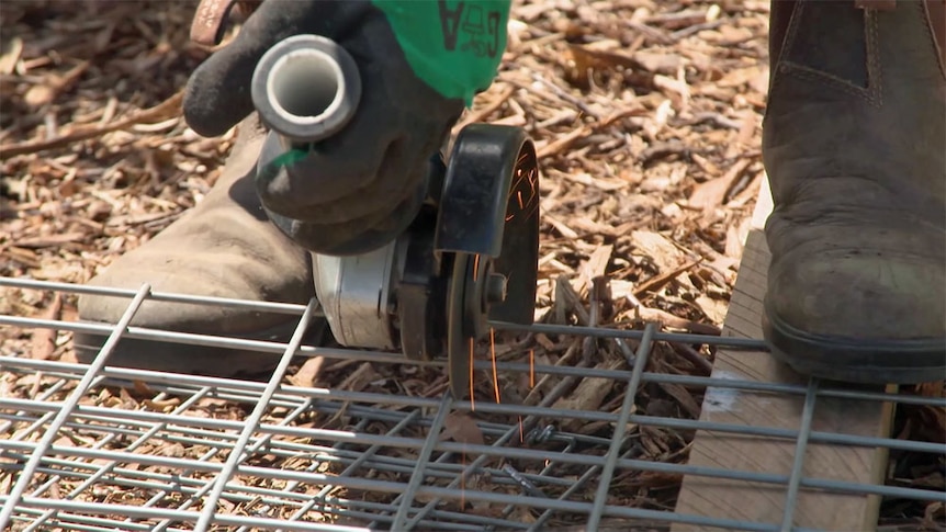 Angle grinder cutting galvanised wire mesh.