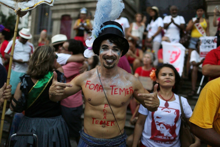 Man with the words 'Out Temer' written on his bare chest at a pre-Carnival street party.