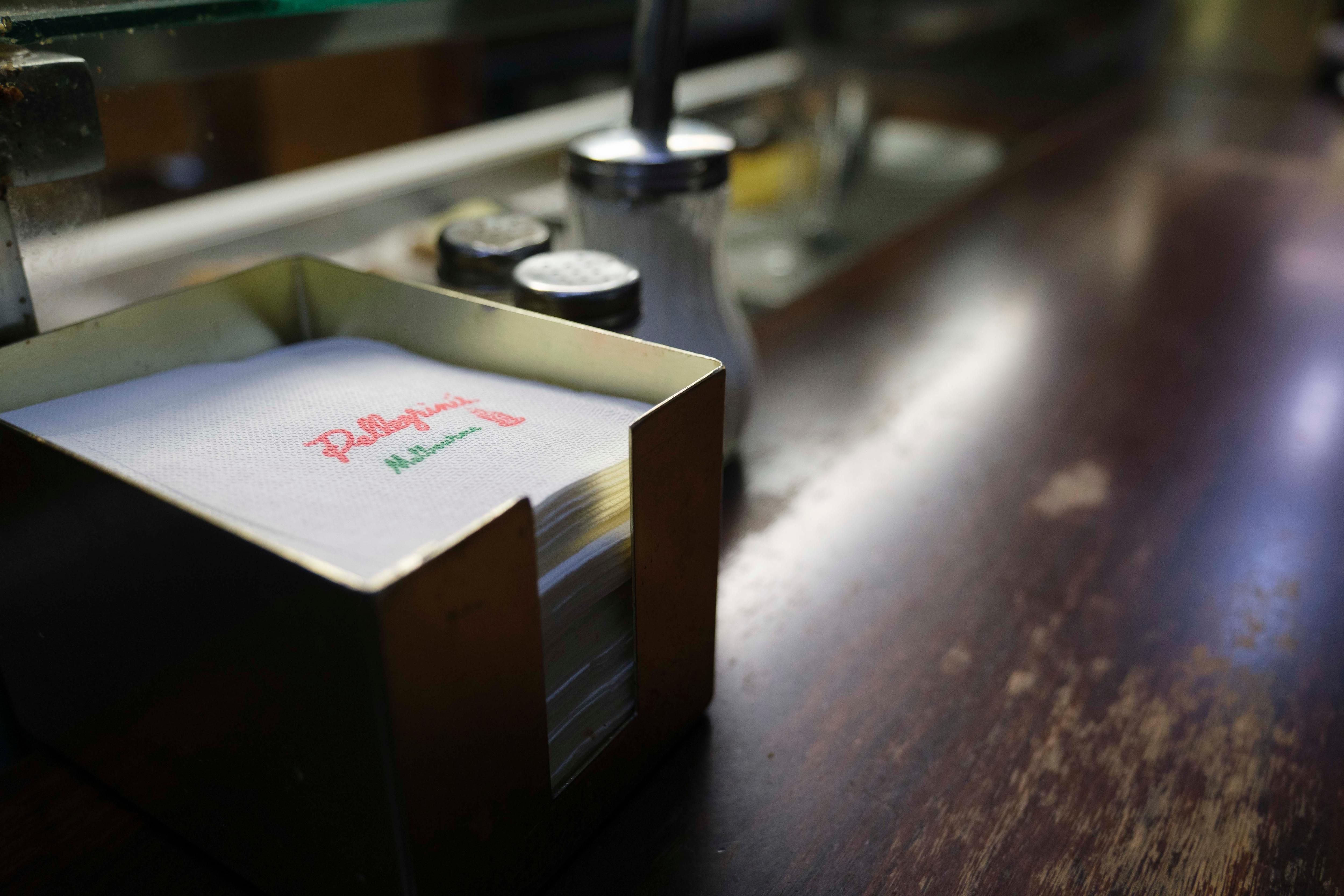 Napkins sitting on a counter top with the Pellegrini's logo imprinted on them.