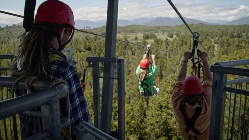 View from an elevated tower where two people are on a zipline.