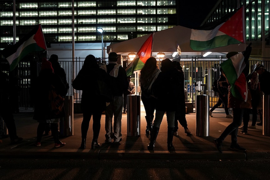 People protest outside the UN headquarters as United Nations Security Council members attend a meeting.