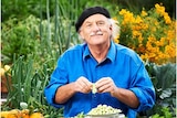 A person sitting in a garden preparing food