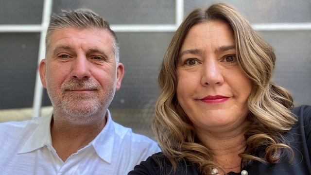 A man and a woman smile in a selfie.