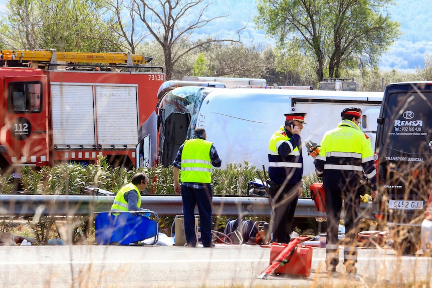 Emergency personnel operate on the Spanish motorway following a fatal bus accident.
