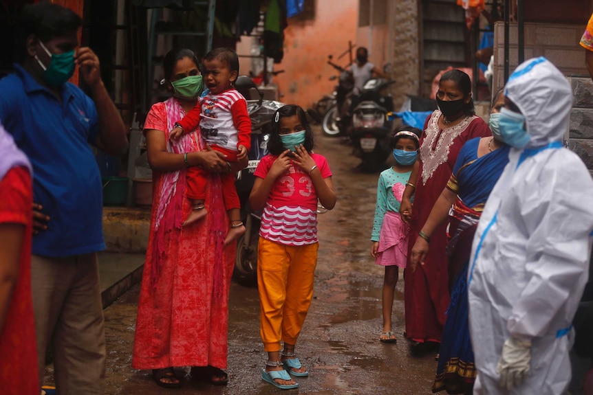 People wait for a screening of COVID-19 symptoms in Dharavi, one of Asia's biggest slums, in Mumbai, India.