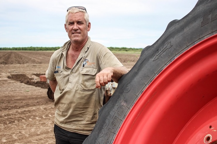 David Menzel leaning on a tractor wheel at his farm in Kununurra.