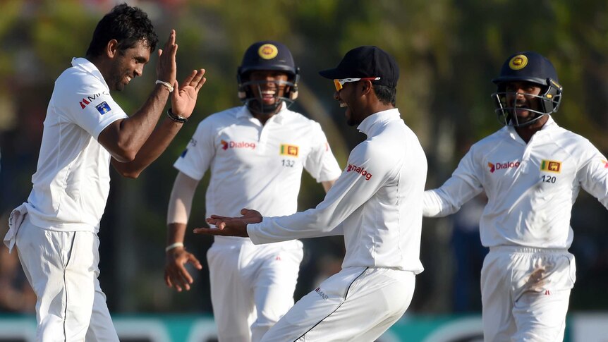 Sri Lankan cricketer Dilruwan Perera celebrates with teammates