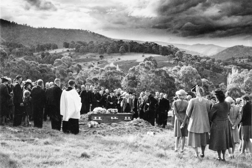 Balck and white 1940s of community at graveside in rural cemetary