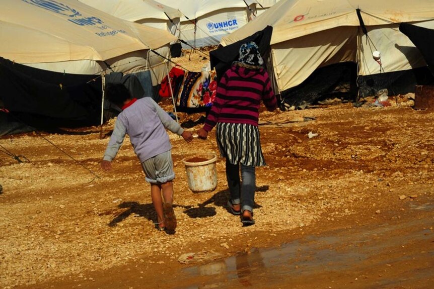 Children carry water at Za'atari refugee camp