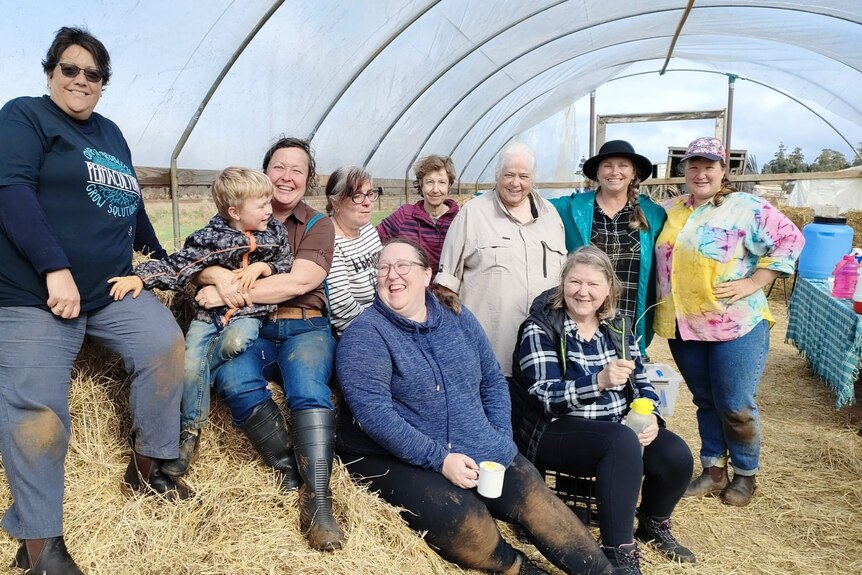 A group of around 20 people in a garden shed posing for a photo on their lunchbreak