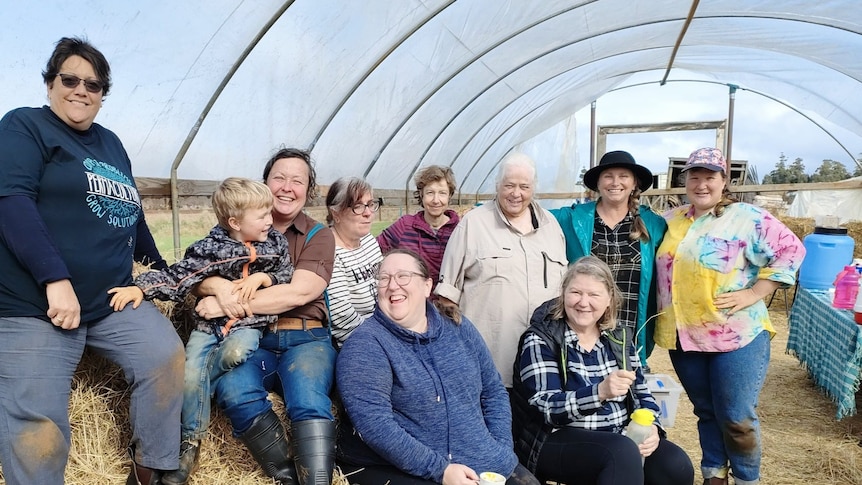 A group of about 20 people in a garden shed.