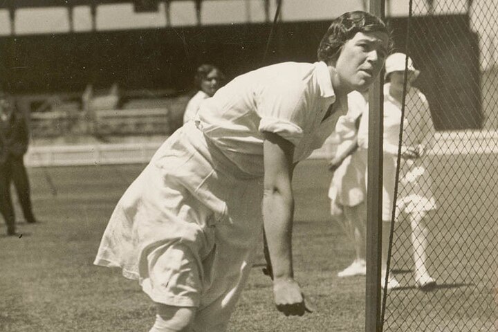 A black and white image of Myrtle Maclagan bowling into nets.