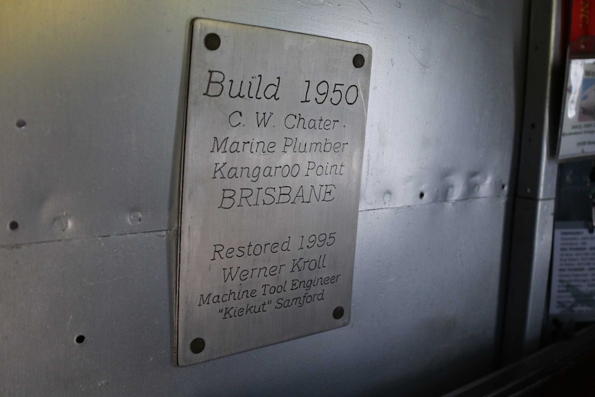 A metal plaque on a wall commemorating the build of an airbus out of a DC-3 plane