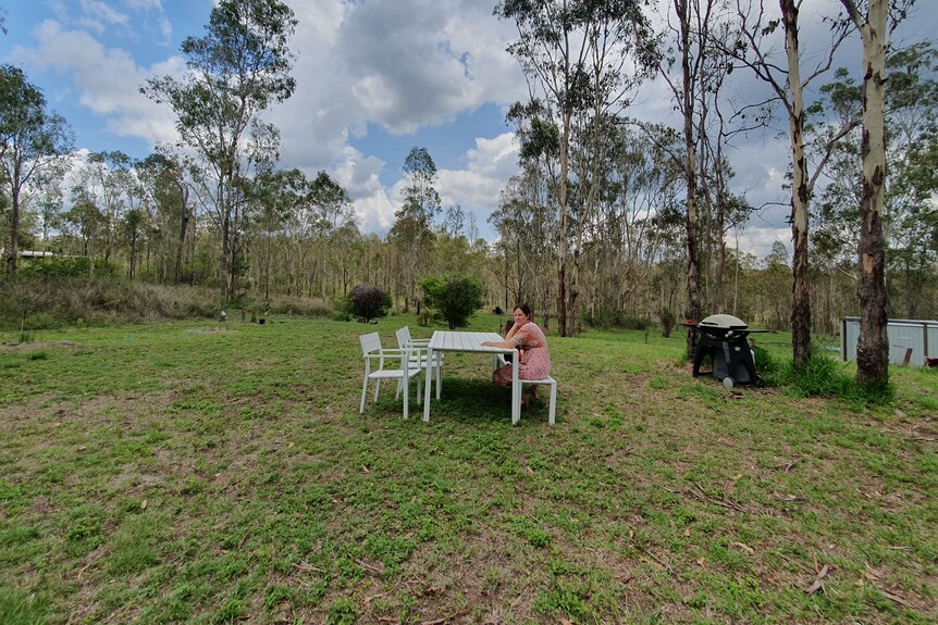 People sitting at outdoor table on big patch of grass
