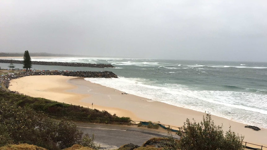 Large, choppy waves and grey sky over the beach at Port Macquarie.