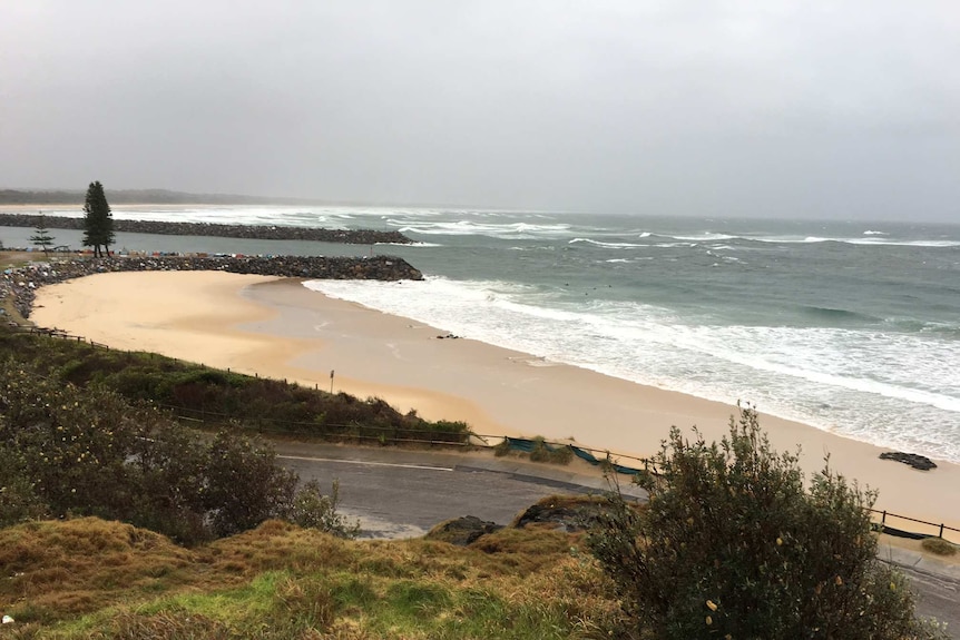 Large, choppy waves and grey sky over the beach at Port Macquarie.