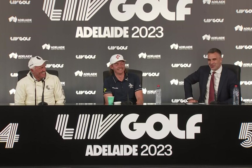 Three men sitting on stage in a press conference for LIV Golf Adelaide 2023