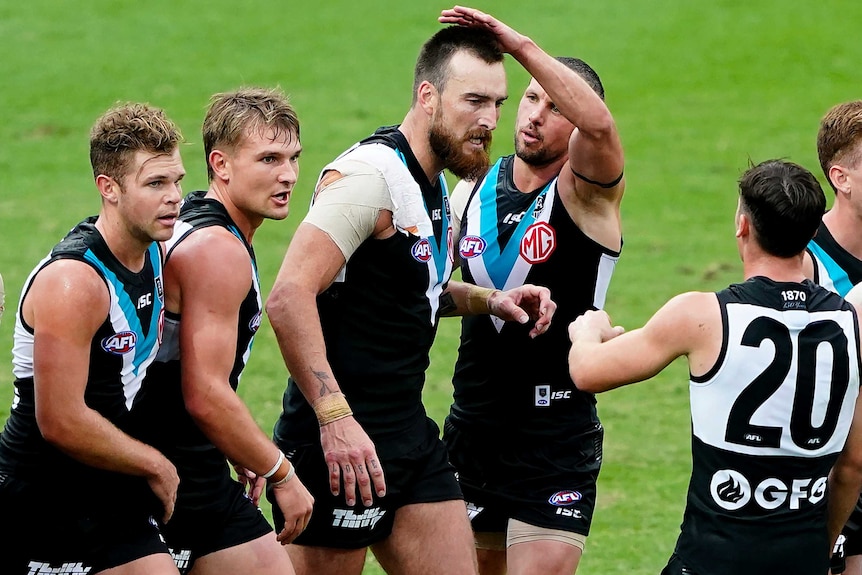 A number of Port players converge around Charlie Dixon to give him high fives and pats on the head