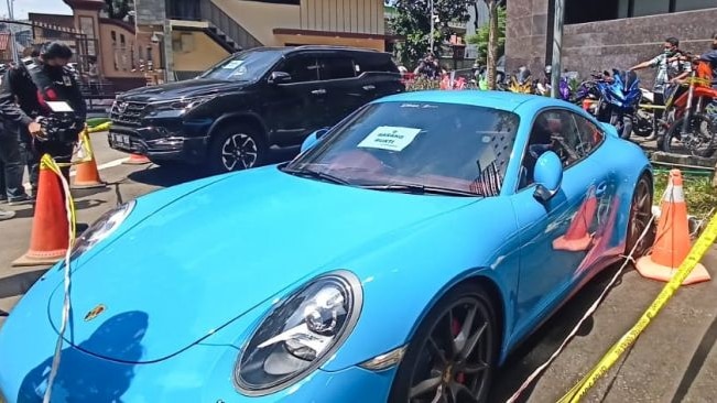 Blue Porsche car and a Toyota Fortuner parked outside the police headquarter.