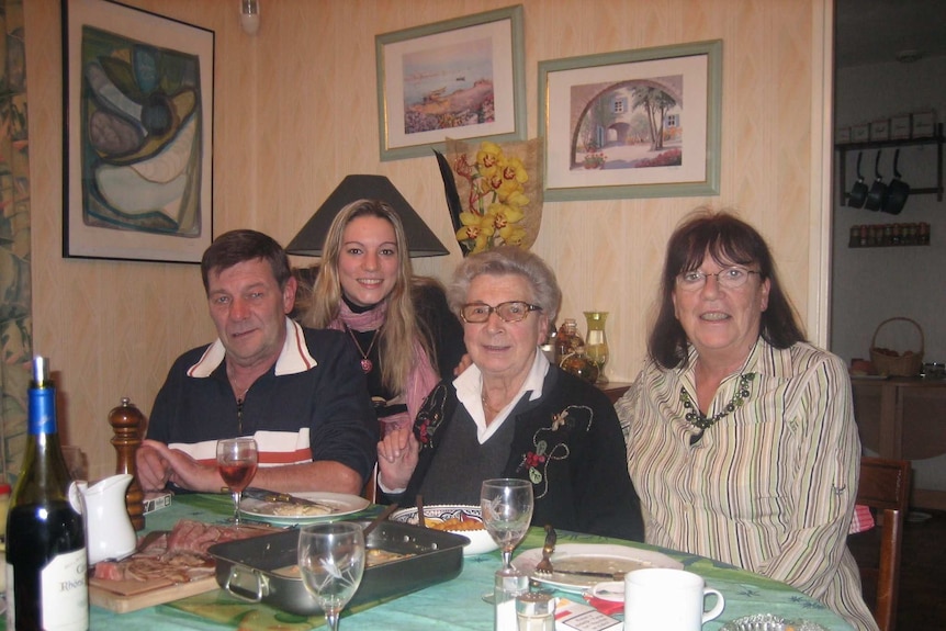A woman with her father, mother and grandmother at a dining table