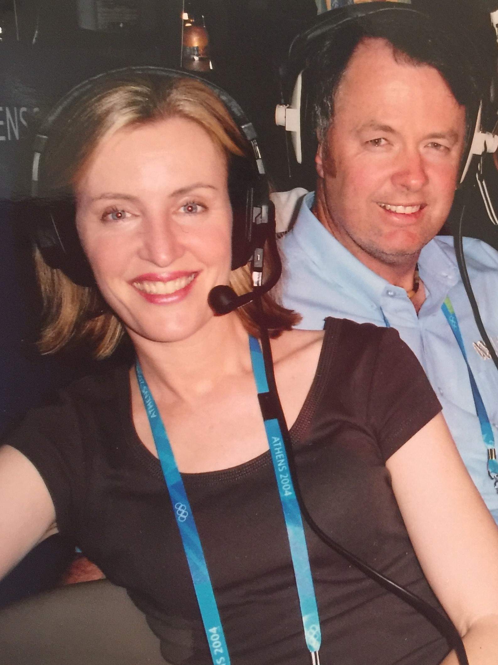 Woman and man wearing headphones in broadcasting box.