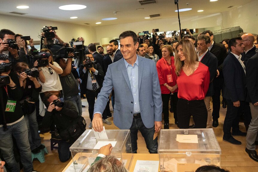 Spanish Prime Minister and Socialist Party candidate Pedro Sanchez casts his vote surrounded by cameras.
