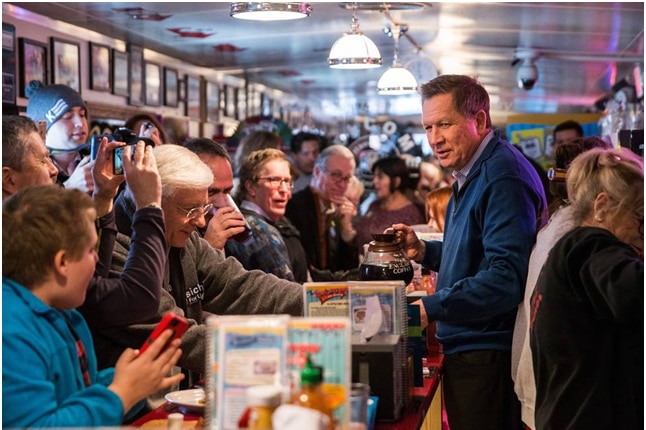 Republican presidential contender John Kasich serves coffee at a diner in New Hamsphire