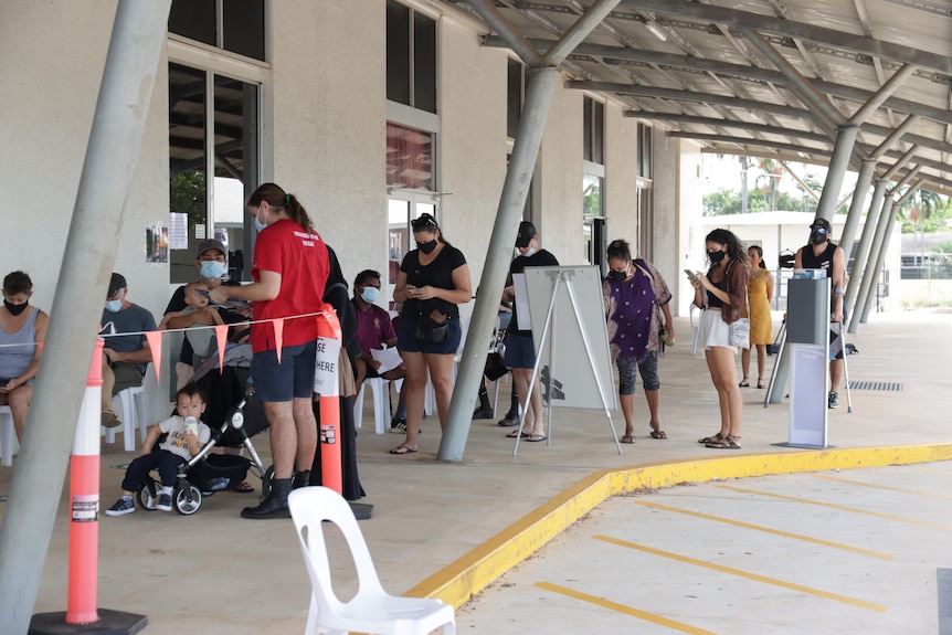 People stand in line outside a Darwin vaccination centre.