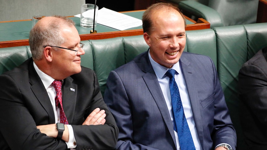 Peter Dutton and Scott Morrison smile, sit next to each other