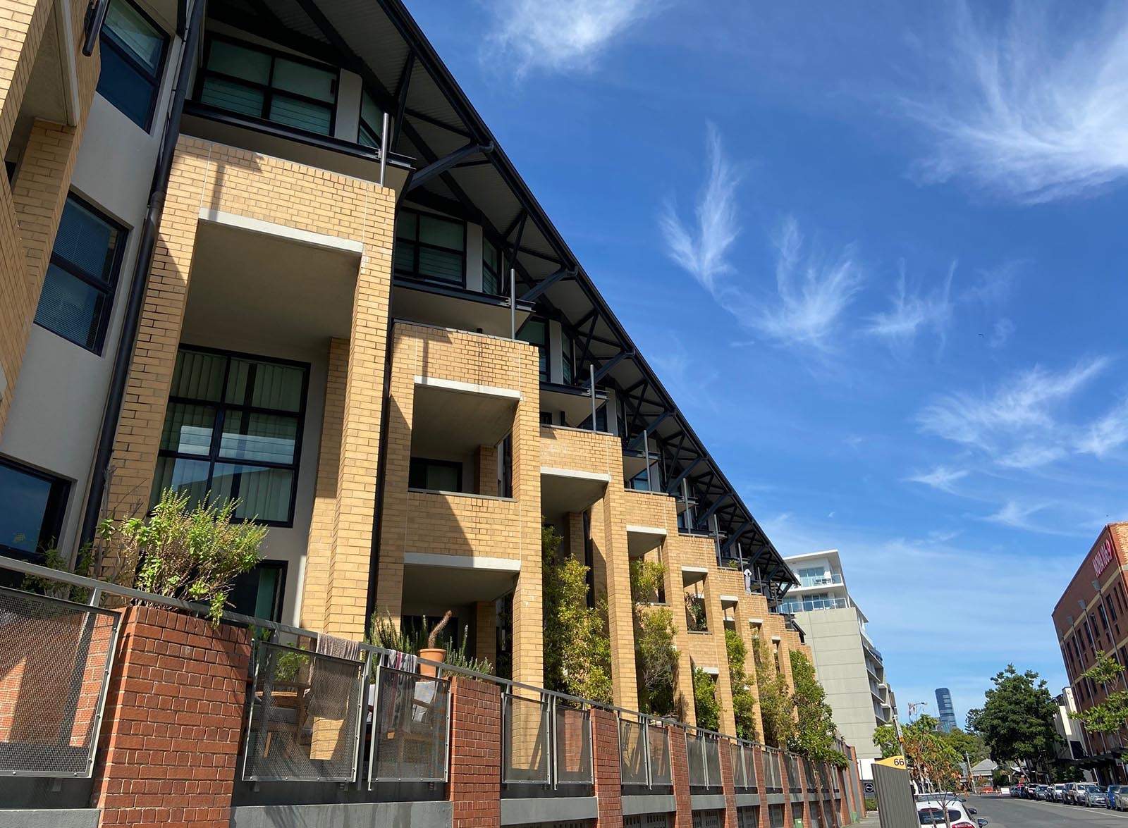 A large low-rise residential apartment block seen from the street