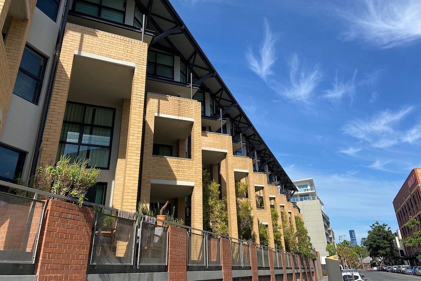 A large low-rise residential apartment block seen from the street