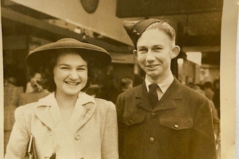 A black and white photo of a young man and his sister in the 1940s, the main in an airforce uniform.