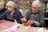Two elderly women creating felt flowers