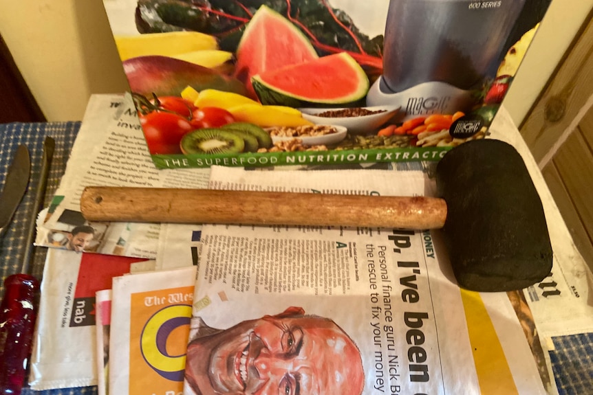 A mallet sits on a copy of a newspaper. 