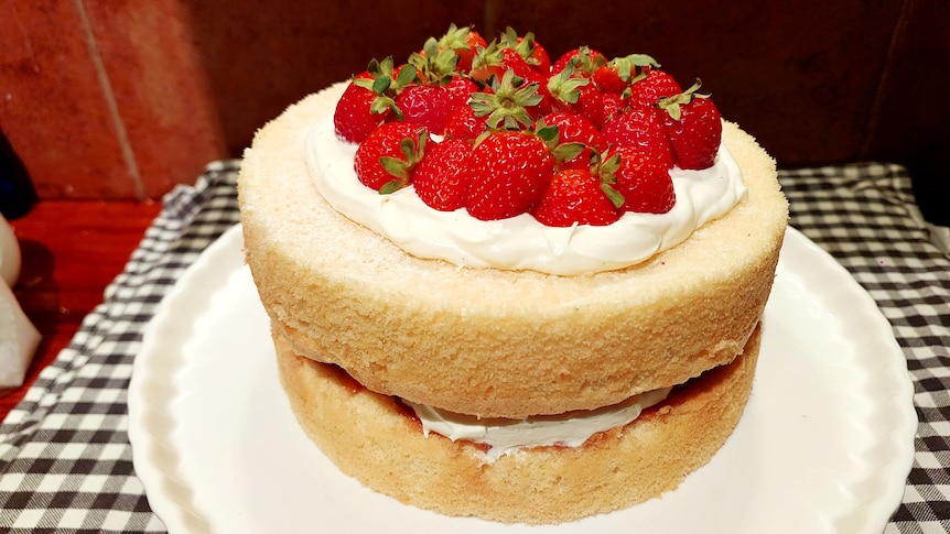 A Victorian sponge cake topped with fresh cream and strawberries, made with pantry ingredients.