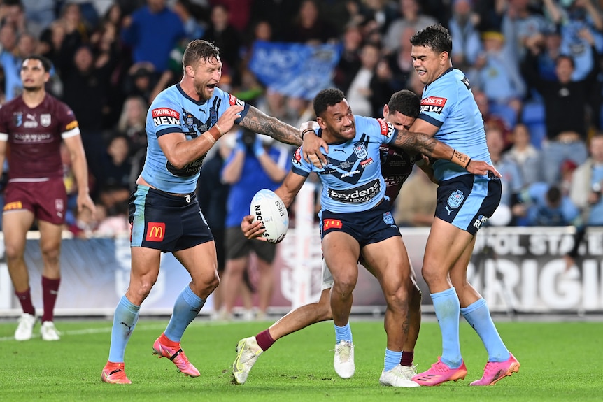 Apisai Koroisau throws a rugby ball up in the air