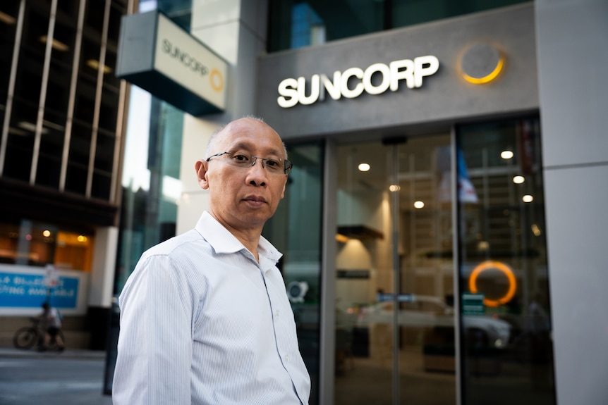 Meng Wong has a stern expression as he stands outside a Suncorp Bank branch in Perth.
