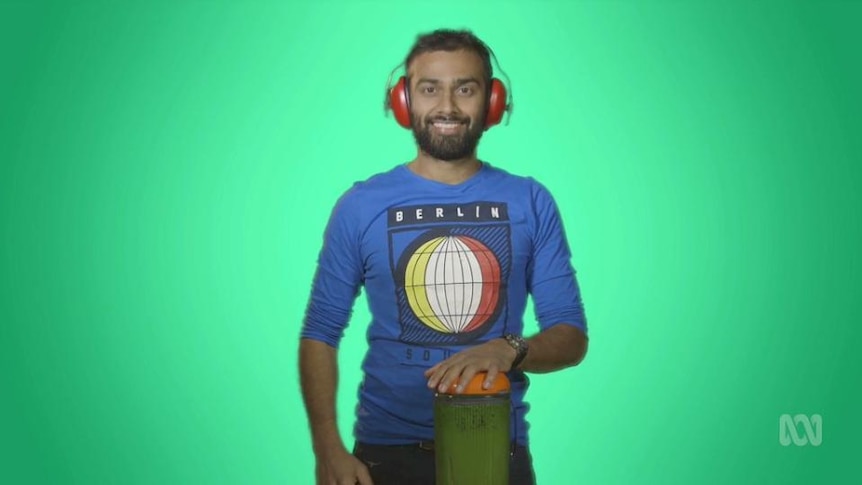 Man stands wearing headphones on ears