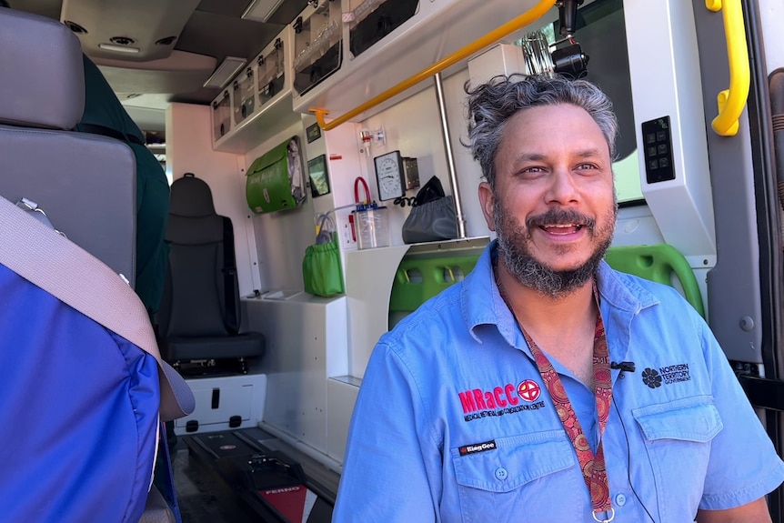 Dr Warren Adie at the back of an open ambulance.